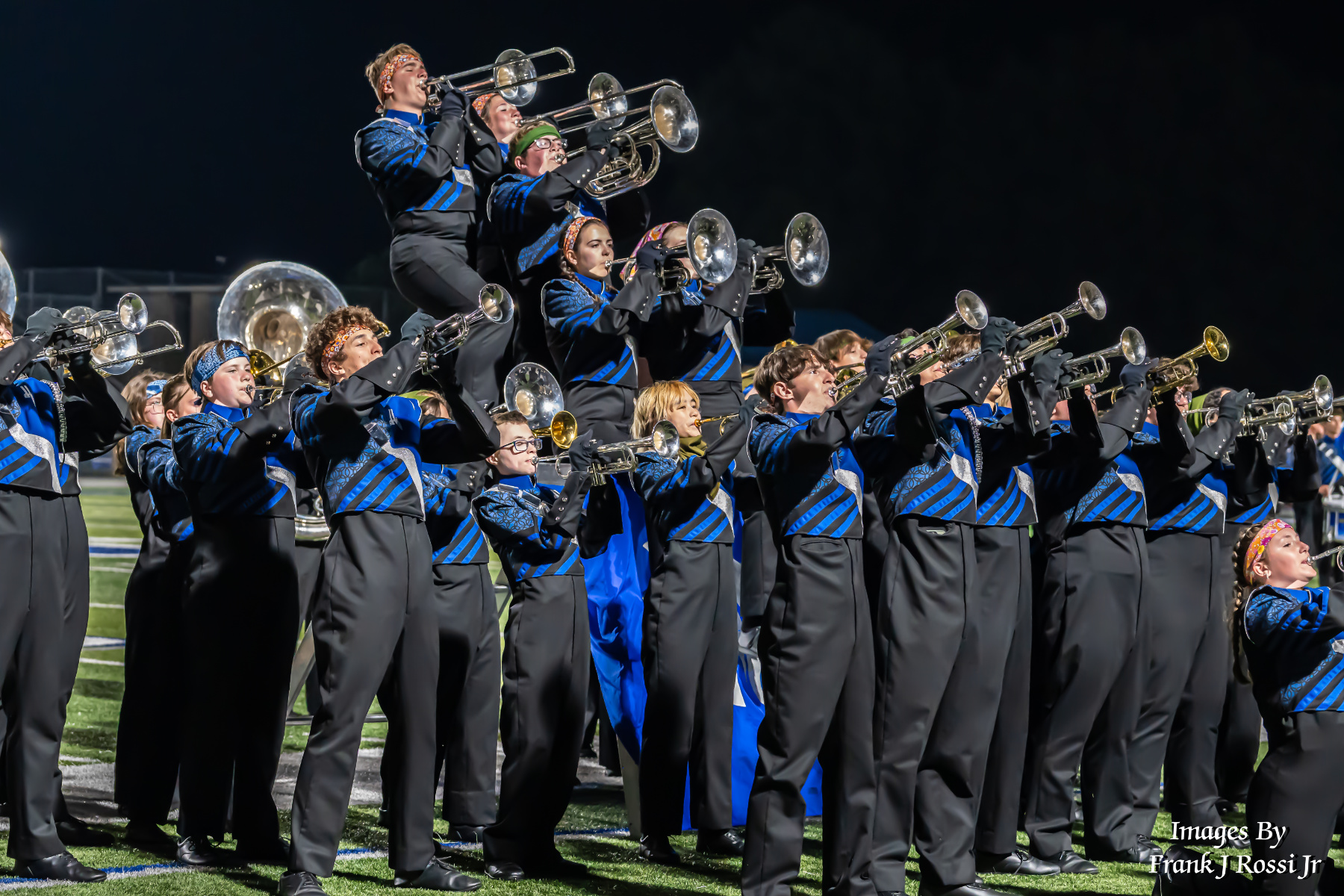 Eli playing the trombone in marching band on the field.